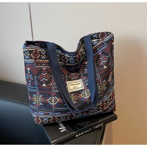 Detail of colorful geometric woven pattern and brand label on canvas bucket bag