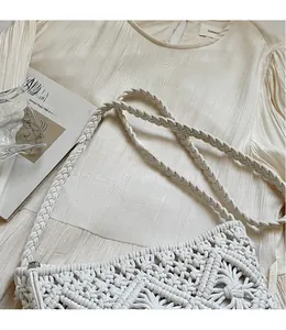 Close-up of handmade white woven crossbody bag with artistic hollow texture and strap