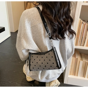 Detail of grey felt shoulder bag with black polka dots and delicate bow embroidery