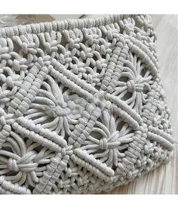 Detailed view of the intricate 3D hand-woven texture on the cream straw shoulder bag