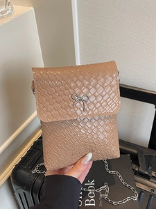 Brown woven texture crossbody bag with silver bow accent and delicate chain strap