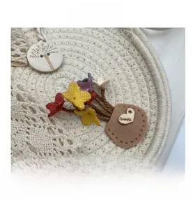 Detailed close-up of woven straw bag with crochet flowers and wooden button decoration