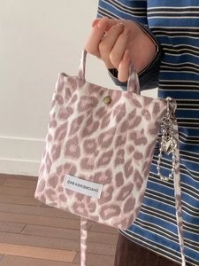 Pink leopard print canvas crossbody bag with decorative silver heart chain strap