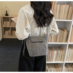 Detail of grey leopard print bucket bag with suede texture and contrast stitching for women