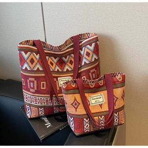 Detail of red and orange canvas bucket bag set with ethnic embroidery and wide strap