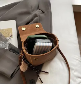 Detailed view of brown crossbody bag interior showing space for phone and wallet