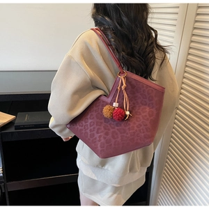 Deep burgundy leopard print tote bag with V-cut opening and plush ball pendant detail
