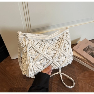 Close-up of handmade woven envelope bag with geometric diamond pattern and fringe