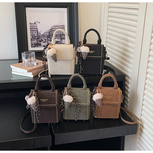 Detail of multi-color structured handbags with studded edges and plush charm accents