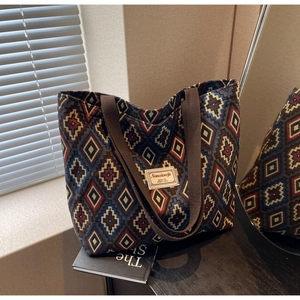 Detail of canvas bucket bag with ethnic geometric pattern and brown shoulder strap
