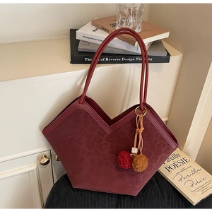 Detail of burgundy leopard print tote bag with V-shaped edge and fluffy pompom charm
