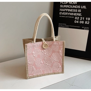 Close-up of pink embossed rose jacquard fabric and natural jute weaving on a tote bag