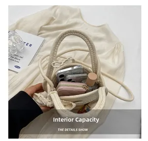 Macro view of woven straw bag interior capacity showing phone, wallet and perfume