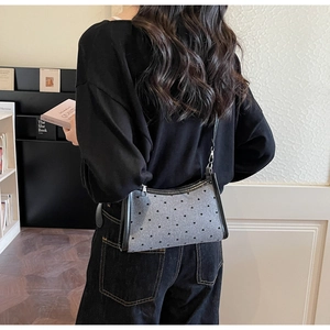 Detail of the heart polka dot shoulder bag showing the silver zipper and compact leather trim