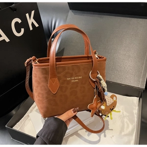 Brown leopard tote bag detail with golden logo, bear charm and detachable strap
