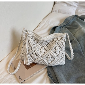 Detail of white handmade woven cotton crossbody bag featuring side tassels and geometric pattern