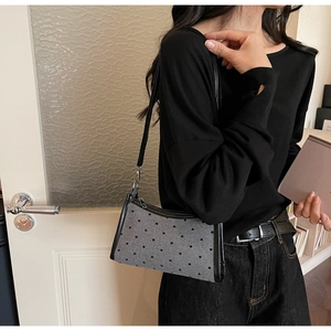 Close-up of gray underarm bag with black heart prints and stylish bow detail