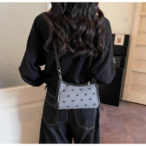 Polka dot bow pattern underarm bag shown on a model for size and style perspective