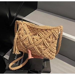 Detailed close-up of handmade woven straw bag featuring tassel and 3D diamond pattern weave