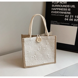 Detail of floral jacquard linen tote bag with woven handles and relief rose patterns