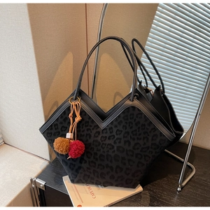 Detail of leopard print tote bag with V-shaped opening and plush pompom charm