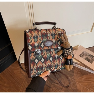Detail of vintage multicolor woven backpack with leather flap and bunny plush charm