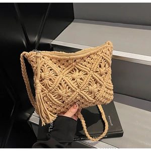 Close-up of beige woven shoulder bag featuring bohemian crochet patterns and long side tassels