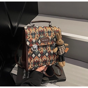 Detailed close-up of geometric quilted texture fabric with rabbit charm on a backpack