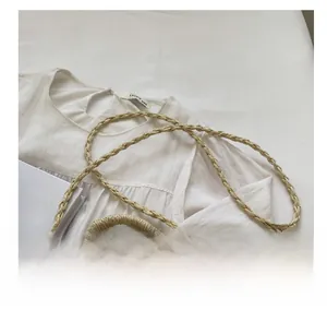 Close-up of handmade straw shoulder bag with delicate white lace trim and drawstring closure