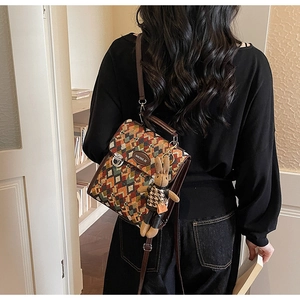 Detail of retro geometric woven backpack featuring brown leather trim and cute bunny charm