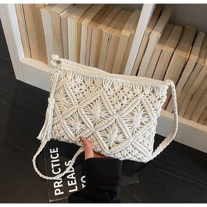 Detail of cream macrame crossbody bag featuring bohemian texture and fringe tassel