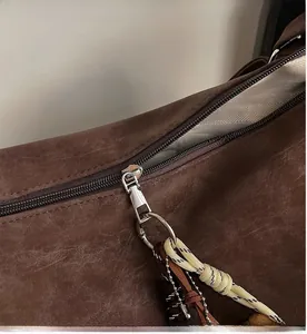 Détail d'un sac vintage avec fermeture éclair argentée et doublure en tissu chevron