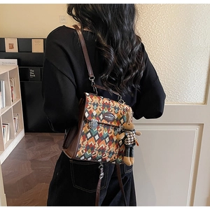 Detail view of colorful geometric texture backpack with vintage leather and rabbit charm