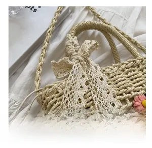Detailed straw bucket bag featuring lace bow tie and 3D floral accents in close-up shot
