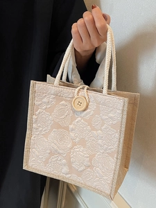 Linen tote bag with white relief rose pattern and rustic wooden button closure