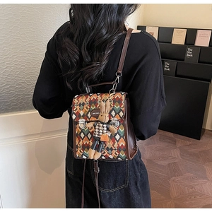 Detail of multi-color geometric weave backpack with brown leather trim and metal clasp