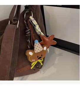 Détail de l'ours en peluche et pendentif étoile en cuir sur un sac à main marron