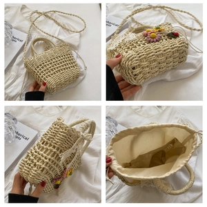 Detail view of straw bucket bag featuring floral embroidery and lace drawstring closure