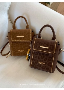 Detailed view of retro leopard print suede handbags with gold studs and wooden bead charms