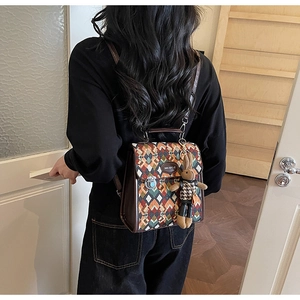 Detail of geometric patchwork backpack with textured fabric and leather trim