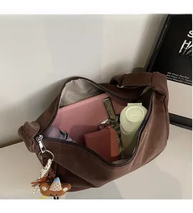 Sac bandoulière rétro marron foncé montrant une grande capacité pour iPad et parapluie
