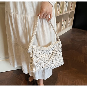 Detailed macro view of white macrame handmade woven bag with tassels and zipper