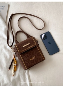 Top view of a brown suede handbag with leopard pattern and colorful wooden bead tassel