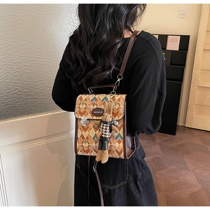 Detail of geometric pattern backpack with rabbit pendant and brand metal logo plate