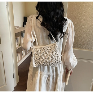 Detail of white cotton woven bag with geometric patterns and fringe for beach vacations