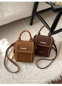 Close-up of leopard embossed crossbody bags in caramel and dark brown faux suede