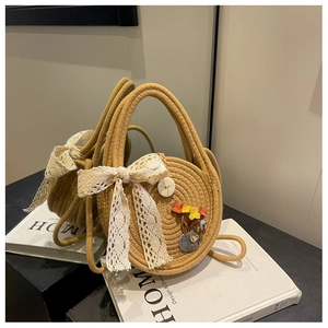 Detail of khaki woven straw bag with lace bow and colorful floral embroidery accents