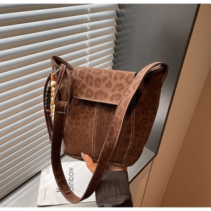 Detail view of brown leopard print crossbody bag with wood bead strap and contrast stitching