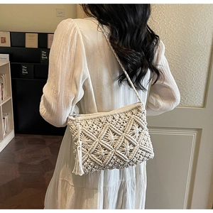 Detail of handmade cream macrame shoulder bag with geometric patterns and fringe