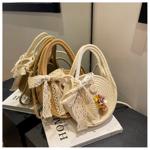 Detail of straw woven handbags with lace bows and flower accents in natural wood styling